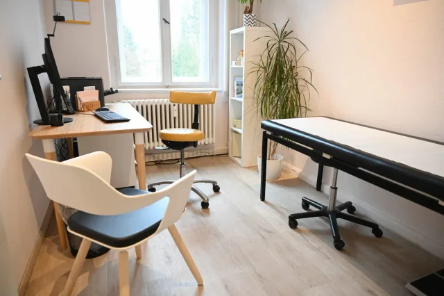 Behandlungszimmer mit Schreibtisch und Liege